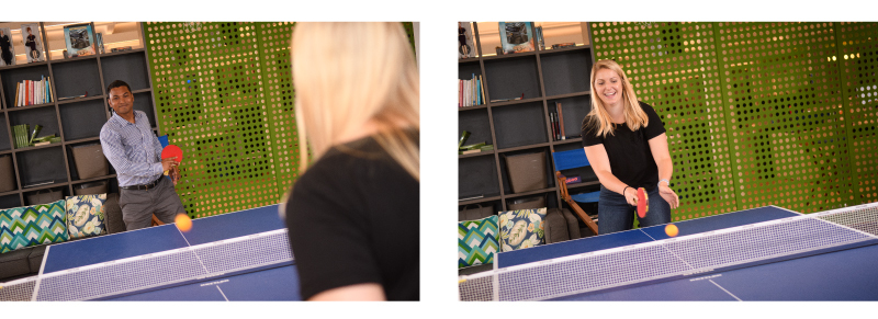 Colleagues playing ping pong in office.